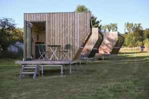 two chairs and a bench in front of a tiny house at Green&Tiny Spot Rehburg an der Schafweide - Sleep Space 3 in Bad Rehburg