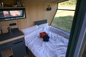 a small bed in a tiny bedroom in a trailer at Green&Tiny Spot Rehburg an der Schafweide - Sleep Space 2 in Bad Rehburg