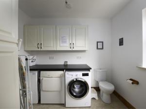 a kitchen with a washing machine and a toilet at Holiday Home Rhea Holiday Home Bantry by Interhome in Tooreen +20 photos