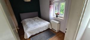 ein kleines Schlafzimmer mit einem Bett und einem Fenster in der Unterkunft Sweet forest cottage near Munich in Oberhaching