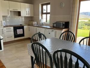 une cuisine avec une table, des chaises, une table et une table. dans l'établissement Holiday Home Achill Sound Holiday Village No 11 by Interhome, à Achill Sound