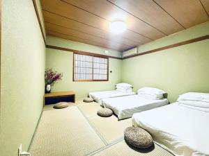 ein Zimmer mit zwei Betten und einem Fenster in der Unterkunft ZYZ Higashijūjō House in Wada