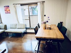 ein Esszimmer mit einem Holztisch und Stühlen in der Unterkunft ZYZ Higashijūjō House in Wada