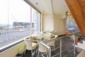 een eetkamer met een tafel en stoelen en een groot raam bij Hotel Nova Inn Near Delhi Airport in New Delhi