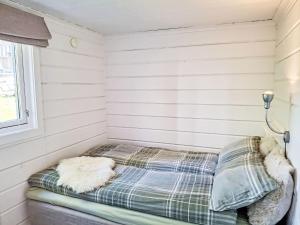 a bed in a small room with a window at Holiday Home Kosestua by Interhome in Madland