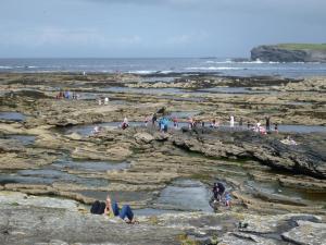 a group of people on the rocks at the beach at Holiday Home Spanish Cove - TR4 D4 - Sleeps 5 by Interhome in Kilkee