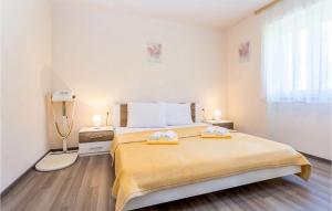 a bedroom with a large bed with two towels on it at Cozy Apartment In Baska With Swimming Pool in Draga Bašćanska