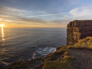 a sunset over the ocean with a cliff at Holiday Home Moore Bay - TR4 HH No 14A by Interhome in Kilkee