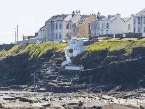 a group of houses on a cliff next to a beach at Holiday Home Moore Bay - TR4 HH No 14A by Interhome in Kilkee +14 photos