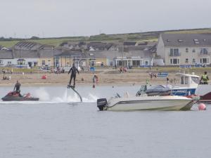 a man is being pulled by a boat in the water at Holiday Home Moore Bay - TR4 HH No 14A by Interhome in Kilkee