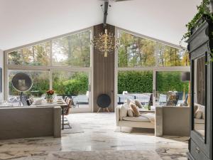 a living room with a chandelier and large windows at Villa Frösakull Paradiset by Interhome in Frösakull