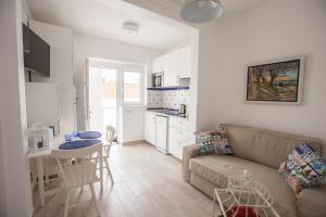 Una sala de estar con un sofá y una mesa y una cocina. en Casas Burnay I, en Ericeira