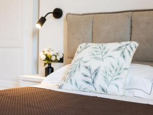 a pillow on a bed with a lamp and flowers at Holiday Home Poggio Piero 1 by Interhome in Montemassi