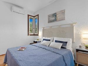 a bedroom with a large bed with a blue blanket at Apartment Iris 5- Terza Spiaggia by Interhome in Golfo Aranci
