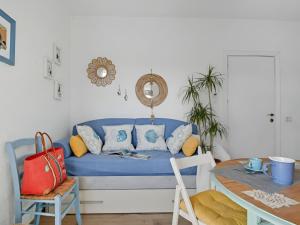 a blue couch in a living room with a table at Apartment Iris 5- Terza Spiaggia by Interhome in Golfo Aranci