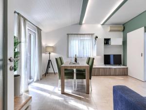 une salle à manger avec une table et des chaises vertes dans l'établissement Holiday Home Tonka by Interhome, à Rabac