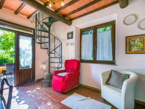 un salon avec une chaise rouge et un escalier en colimaçon dans l'établissement Holiday Home Geranio by Interhome, à Trequanda