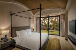 a bedroom with a large bed and a large window at Radisson Resort & Spa Kandla in Gandhidham