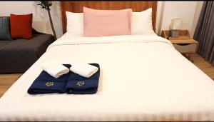 een wit bed met twee handdoeken erop bij Sport villa Huahin, Room 225, Studio Queen Bed pool view and Kitchenette, 2nd Floor in Hua Hin