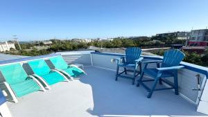 a patio with blue chairs and a table on a roof at 5 Brs, Hot Tub Roof Top, 2Nd Off The Ocean in Loveladies