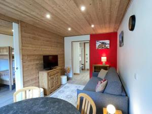 a living room with a couch and a tv at Studio divisible, ski aux pieds, vue sur pistes - FR-1-181-2677 in La Plagne Tarentaise