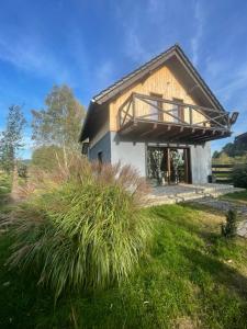 a house with a balcony on the side of it at LumaVa Hause & Spa in Wojcieszyce