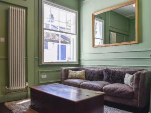 een woonkamer met een bank en een spiegel bij Scarborough Esplanade in Scarborough +38 foto's