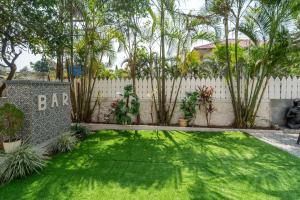 a backyard with a fence and a green yard at EKO STAY Gold - Gatsby Villa in Lonavala