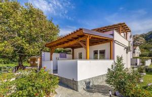 a white house with a wooden roof at Amazing Apartment In Baska With Swimming Pool in Draga Bašćanska