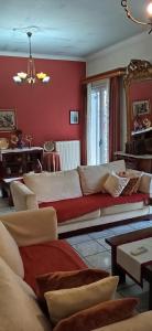 a living room with a couch and a red wall at The Pirate's Mansion in Nafplio