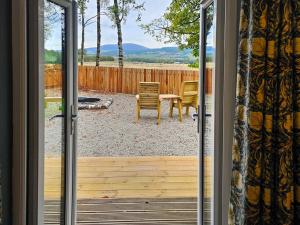 una puerta que da a un patio con mesa y sillas en Gallowhill Kirkside - Uk46515, en Newmill