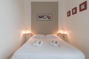 ein Schlafzimmer mit einem weißen Bett und zwei Kissen in der Unterkunft La Birochère - 400 m plage - Parking in Pornic