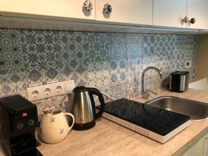 a kitchen counter with a sink and a coffee maker at Cozy 1-bedroom apartment with free parking in Rīga +3 photos