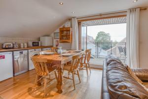 uma cozinha com uma mesa de madeira e um sofá em Crow's Nest - Secluded apartment with Sea Views, Crabpot Cottages, Hunstanton em Hunstanton mais 10 fotografias