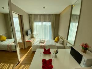 a hotel room with two beds and a table with red bows at Phu Dahla Apartments in Ban Khlong Haeng