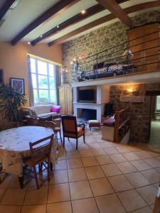 una sala de estar con una mesa y una chimenea en Gîte Le Duzon, en Plats