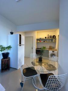 a dining room with a glass table and chairs at Pé na Areia in Barra Velha