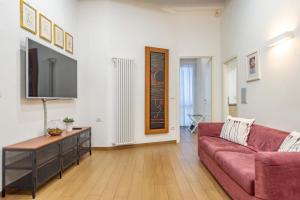 a living room with a red couch and a flat screen tv at La bella Flora in Ariccia
