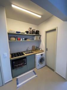 a kitchen with a sink and a washing machine at Pé na Areia in Barra Velha
