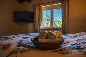 a bowl of towels on a bed with a window at Guest House dei Cavalli in Lobbi