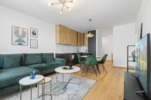 a living room with a green couch and tables at LAM Discovery AC - Balcony in Nivy