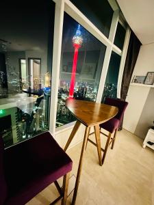 a table and chairs in a room with a view of a tower at vortex KLCC YOUR HOME in Kuala Lumpur