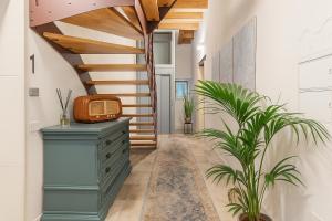 a hallway with a blue dresser and a wooden staircase at Hotiday Apartments Siracusa in Syracuse