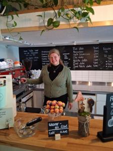 a woman standing behind a counter in a kitchen at Max Hostel in Bonn +26 photos
