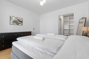two beds in a room with white walls at LAM Discovery AC - Balcony in Bratislava