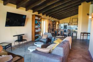 a living room with a couch and a tv at Guest House dei Cavalli in Lobbi