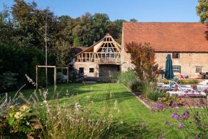 a large brick house with a garden in front of it at The incredible Alsatian house of the 21st century in Hangenbieten