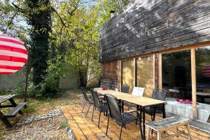a patio with a wooden table and chairs at Szentendrei sziget, modern faház, télen is in Szigetmonostor