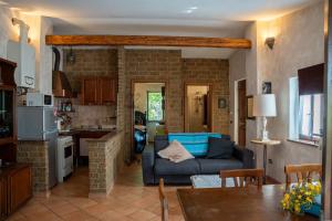 a living room with a blue couch and a kitchen at Guest House dei Cavalli in Lobbi