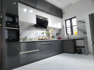 una cocina con armarios en blanco y negro y fregadero en LPMD Apartment, en Ikuata